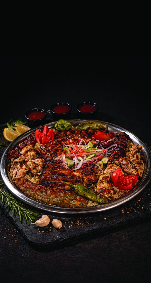 Sufraq BBQ Feast Platter — flame-grilled kebabs and boti over seasoned rice